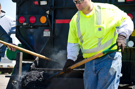 worker shoveling tar