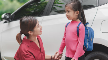 Mom with young girl in front of an SUV