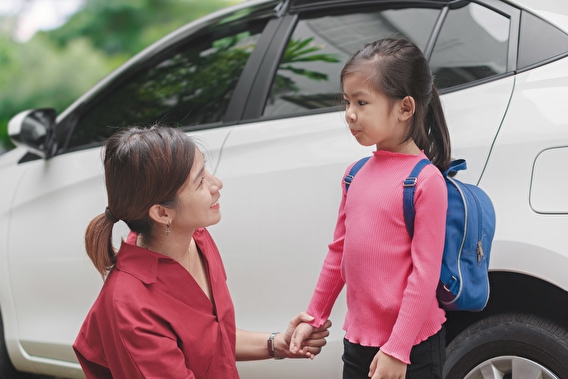 Mom and young daughter in front of an SUV