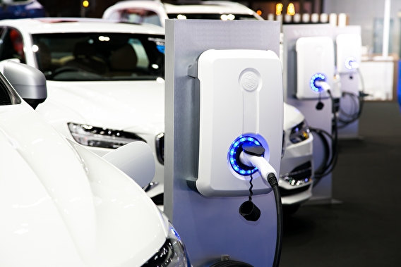 A white cars plugged into electric vehicle charging stations