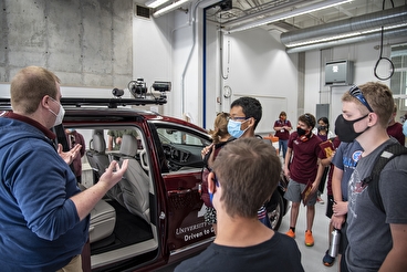 Group of students looking at automated vehicle