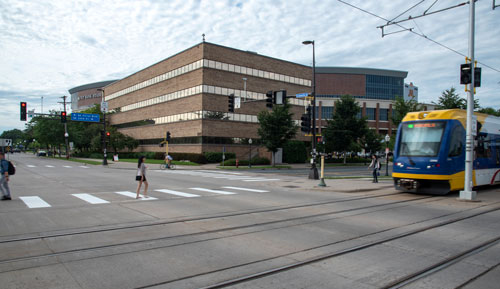 Photo of University Office Plaza with light rail train crossing street