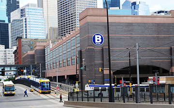 Outside view of ABC Ramp B with busses, light rail train, and pedestrians