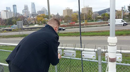 man measuring air quality next to highway