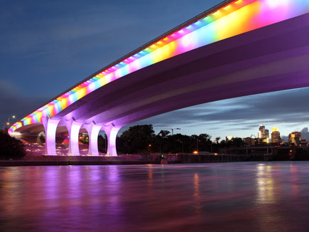 bridge lit with rainbow colors at night
