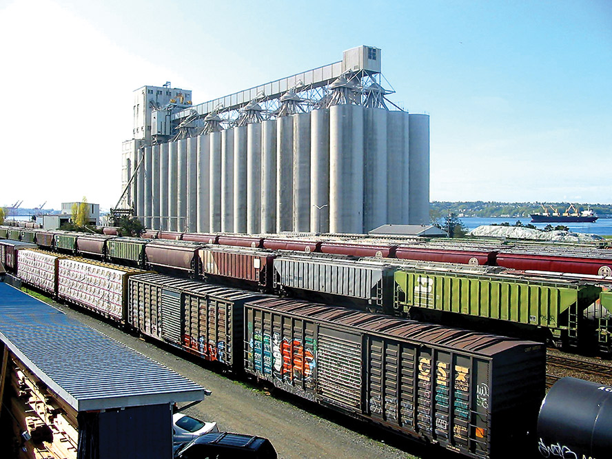 Photo of grain elevators at a port with freight trains