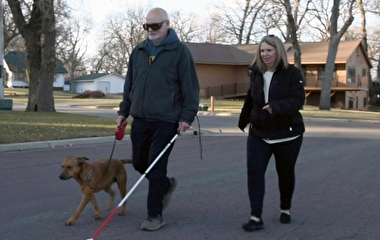 Jim Baker walking his dog using a white cane