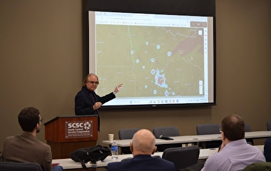 Tom Horan presenting in front of a StoryMap of Minnesota