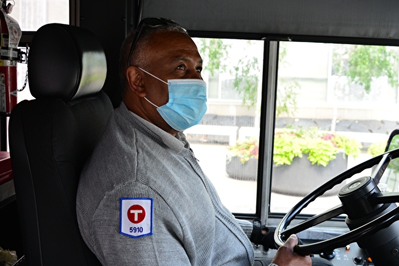 Metro Transit bus driver behind the wheel wearing a medical mask