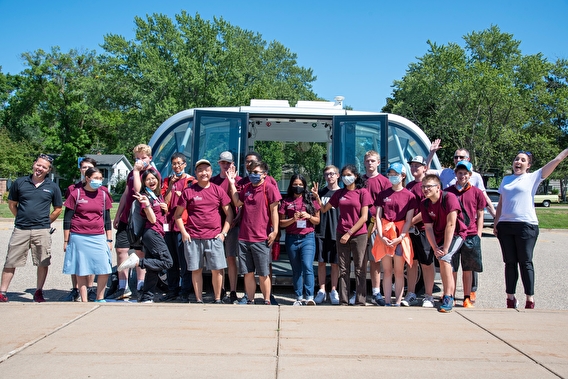 Campers standing in front of the automated shuttle