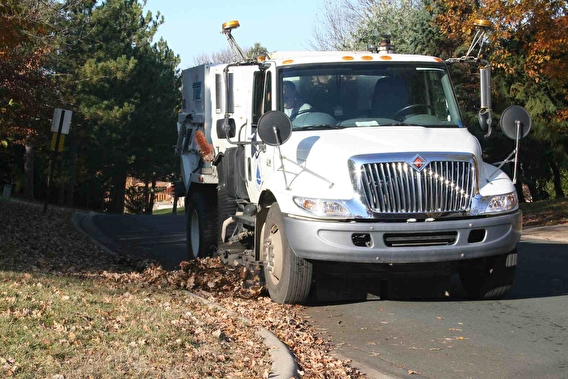 Street sweeper truck cleaning leaves off the street
