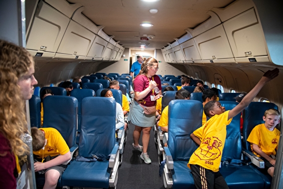 Students sitting in airplane seats during a field trip to MSP