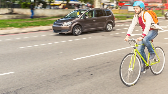 Man riding a bicycle alongside vehicle traffic
