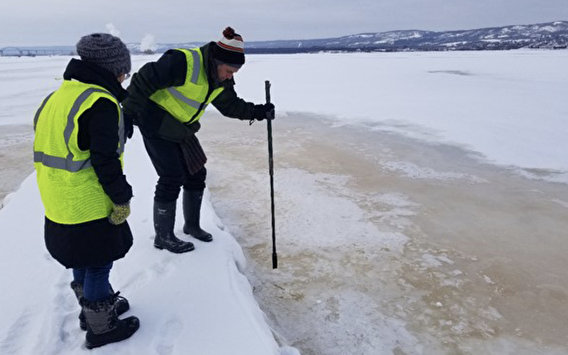 Researchers collecting a water sample in winter