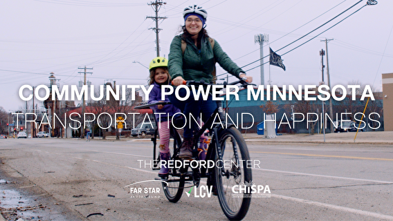 Community Power Minnesota video still with a woman and small child on a bike