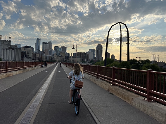 Person riding a bicycle with the Minneapolis skyline in the background