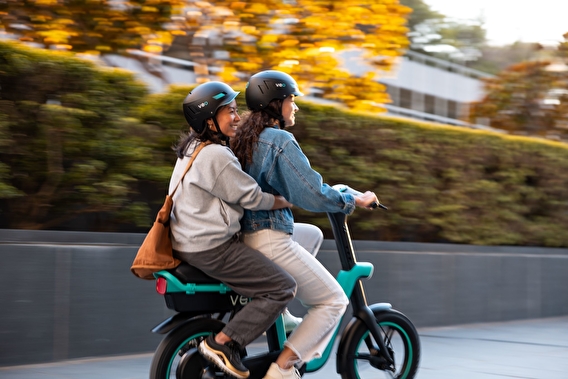 Two people riding a scooter