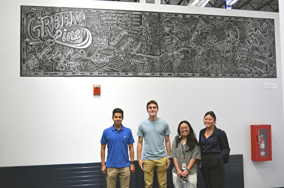 Ramsey County interns and staff posing beneath a mural