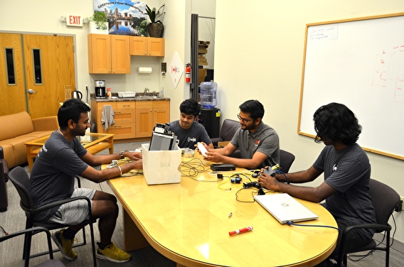 VSI interns sitting around a table with laptops and technology components