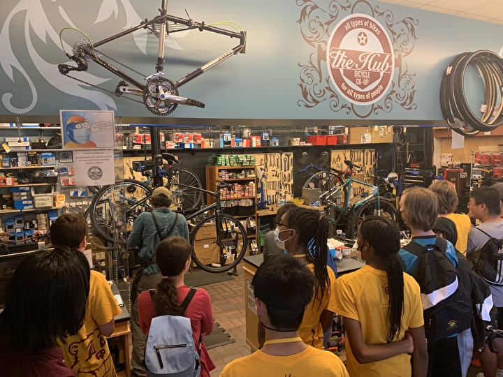 A gorup of students watch a demo of bike maintenance at the University Bike Center