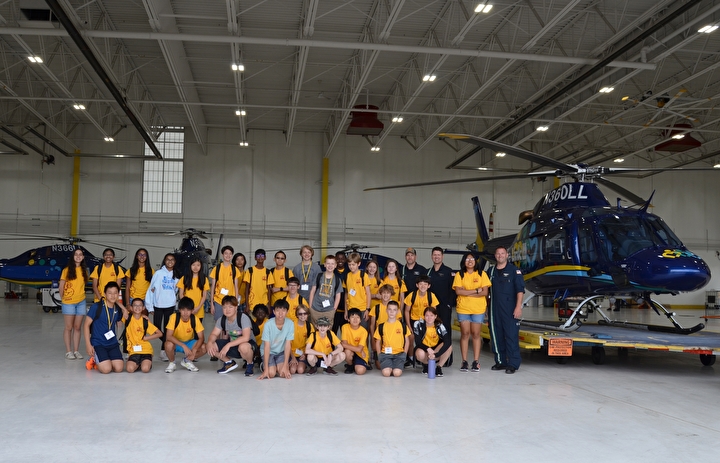 Campers in the LifeLink hangar with helicopters