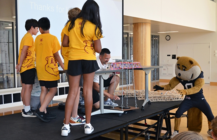 Students put their bridge to the test while Goldy cheers them on