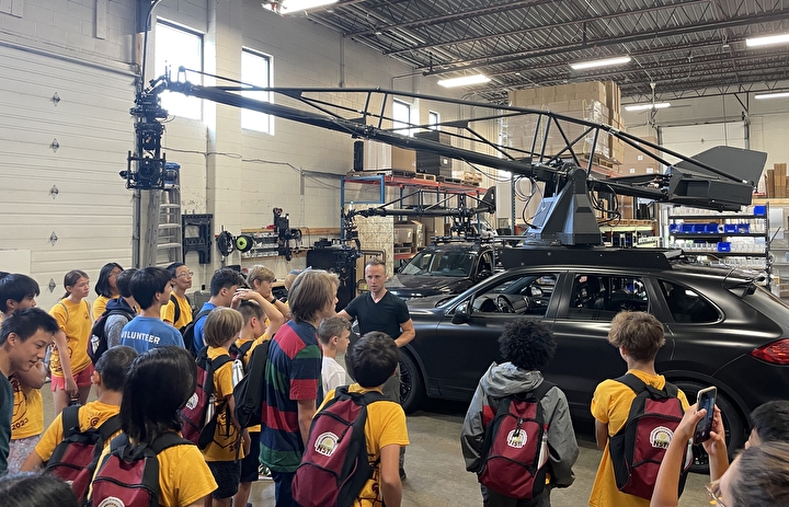 Students viewing a vehicle-mounted camera rig at MotoCrane