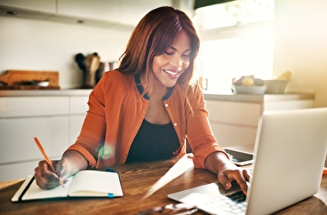Smiling woman working from home on a laptop