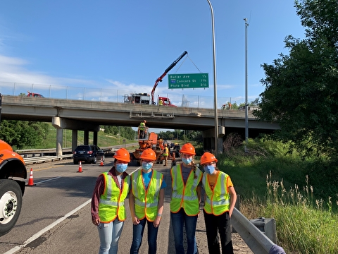 2020 MnDOT interns in the field standing in front of a bridge construction site