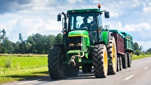 Tractor driving on a rural paved road