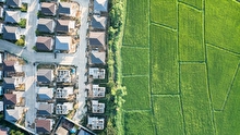 Aerial view of a suburban development bordering green fields
