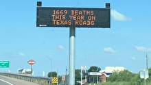 A roadside electronic messaging sign reading "1669 deaths this year on Texas roads"